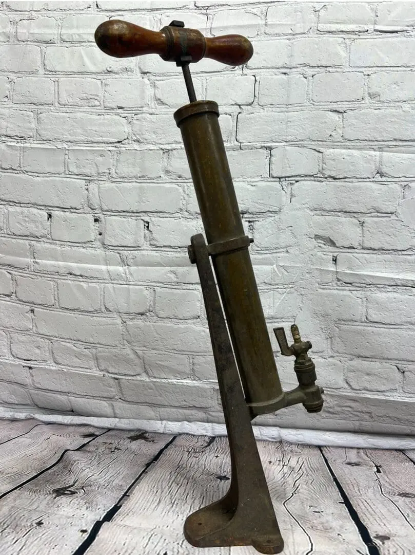 A metal Ashland USA Bilge Pump with a wooden handle.