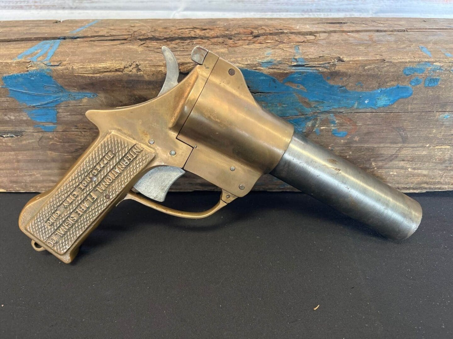 A flare gun # 3 sitting on top of a piece of wood.
