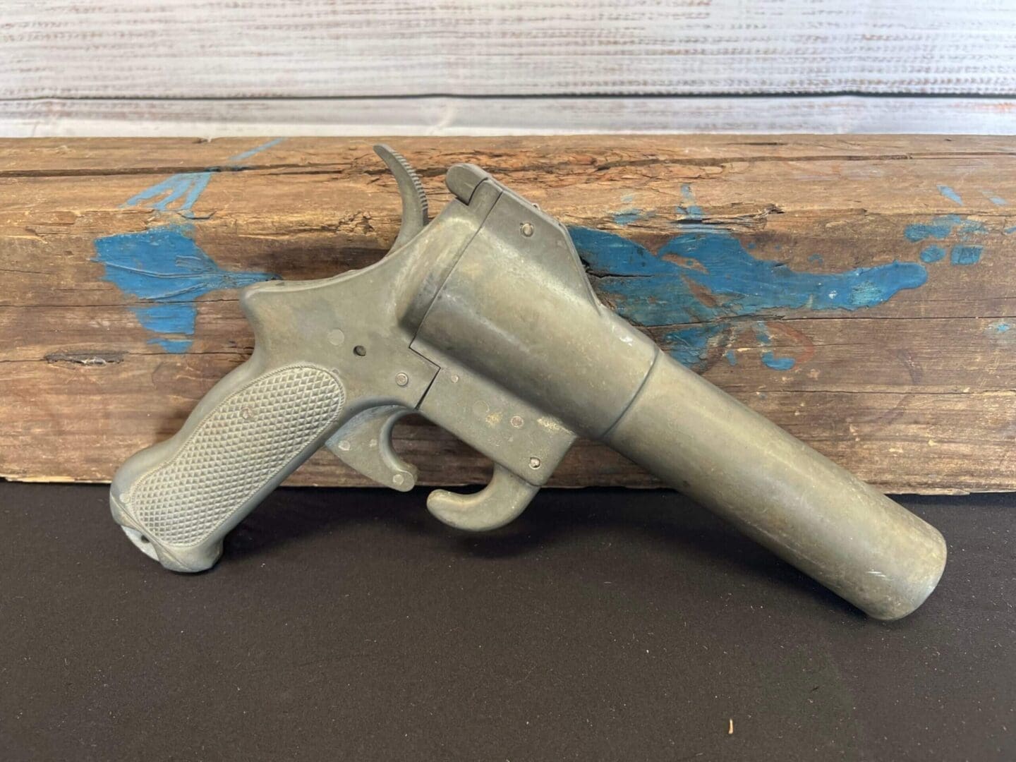 A Flare gun #3 sitting on top of a piece of wood.
