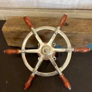 A Small craft wheel with wooden handles 3 on a wooden table.