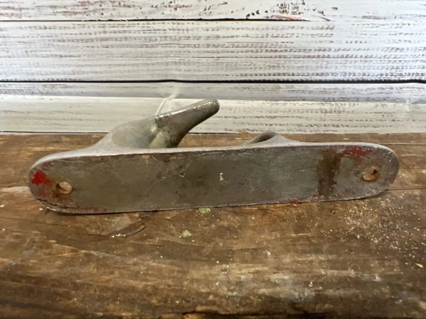A metal tool sitting on top of a wooden table.