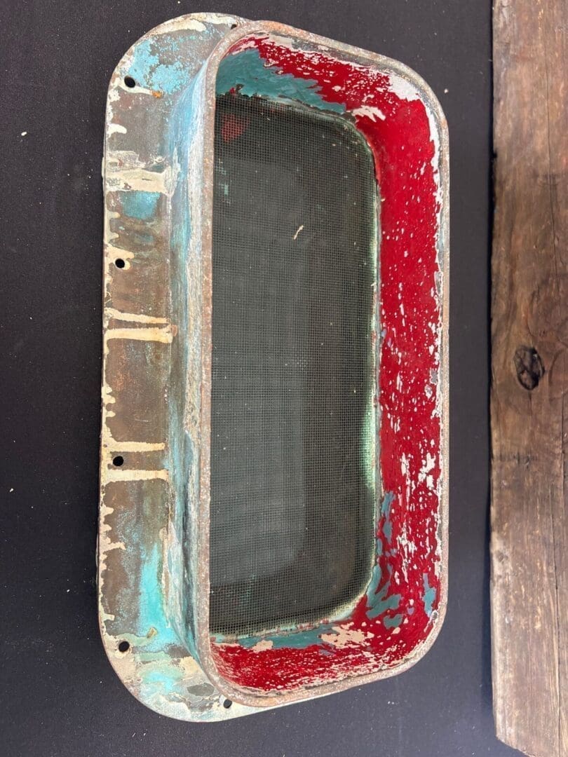 A red and blue metal object sitting on top of a table.