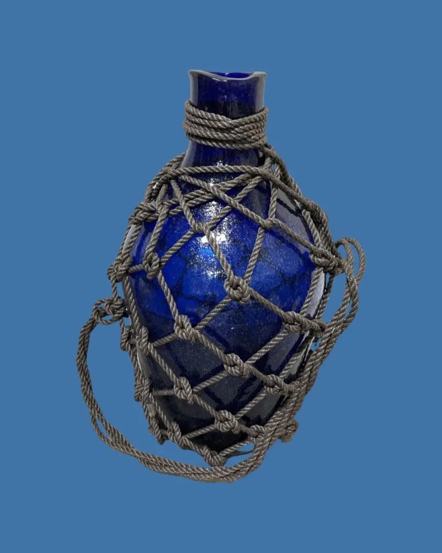 A blue vase with rope wrapped around it.