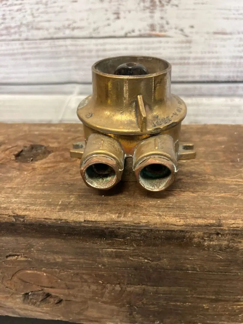 A brass pipe with two valves on top of it.