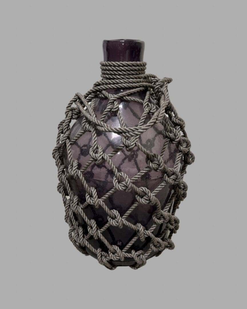 A glass bottle with rope wrapped around it.