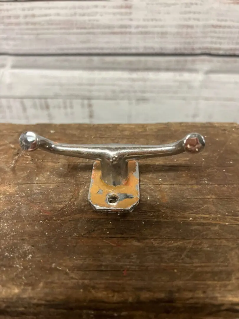 A metal handle on top of a wooden table.