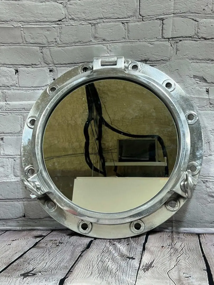 A mirror with a metal frame on the wall.