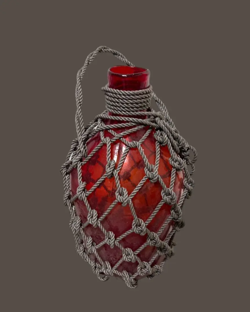 A red glass bottle with a rope wrapped around it.