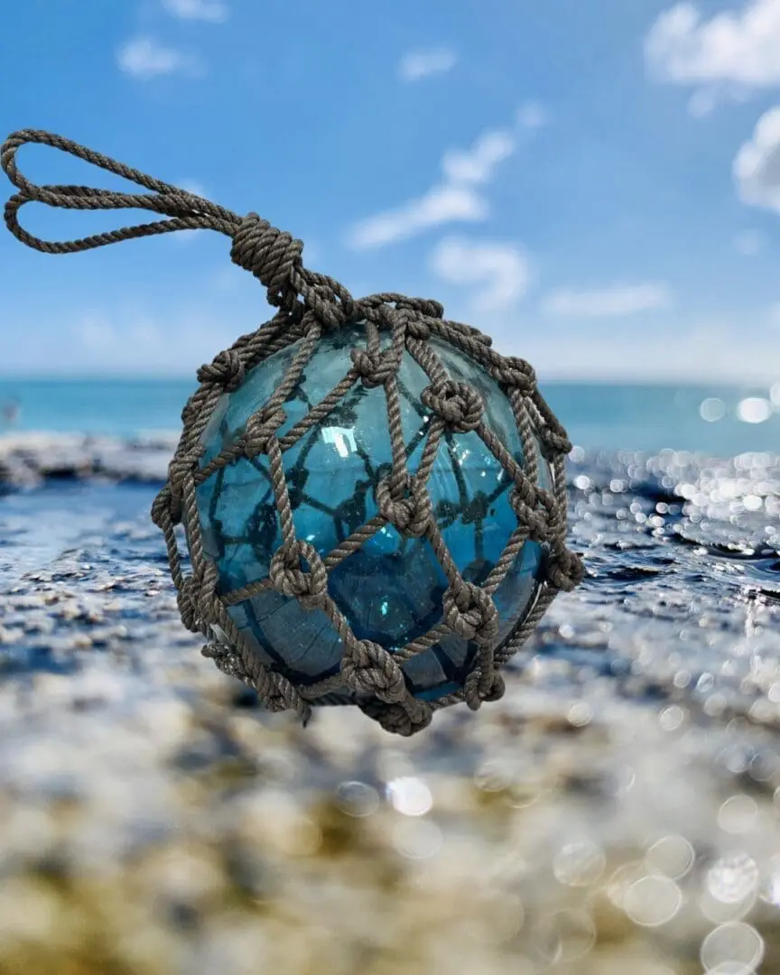 A blue ball of string on the beach