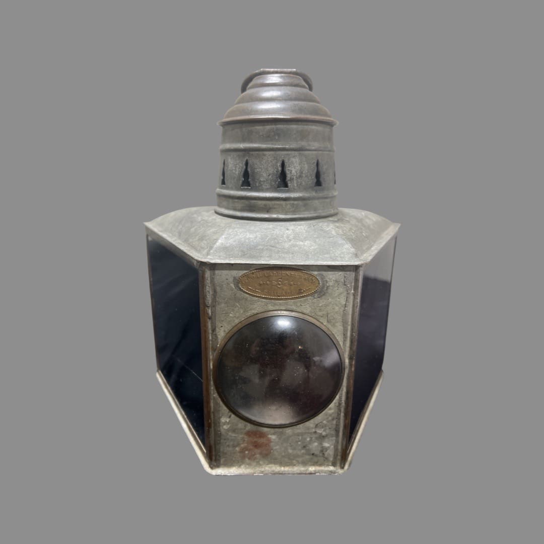 A metal lantern with a silver top on the side.