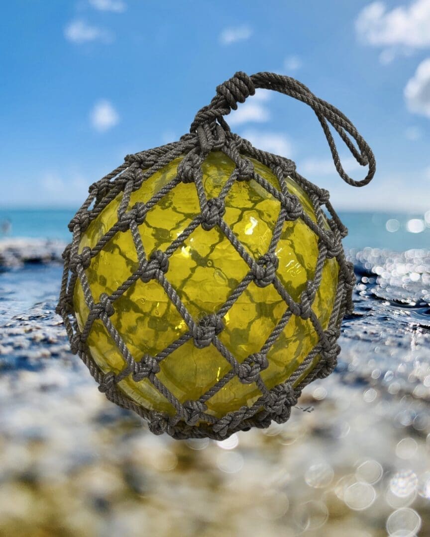 A yellow ball of string on the beach.