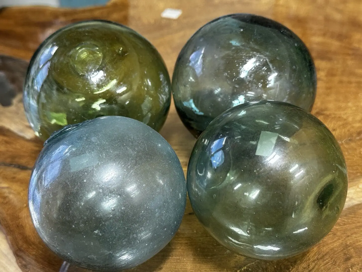 Four glass balls are sitting on a table.