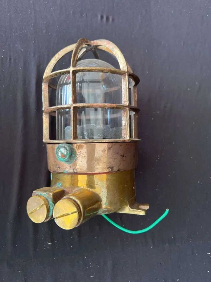 A close up of an old brass light