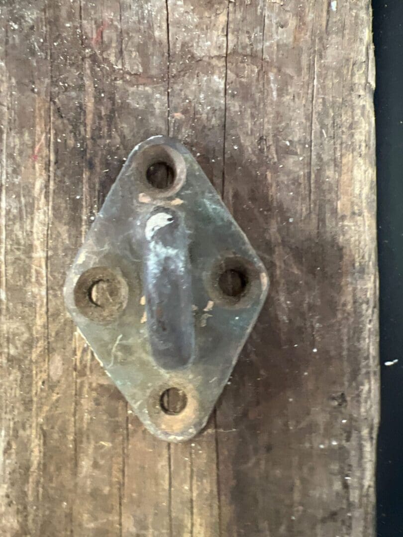 A metal object is attached to the side of a wooden wall.