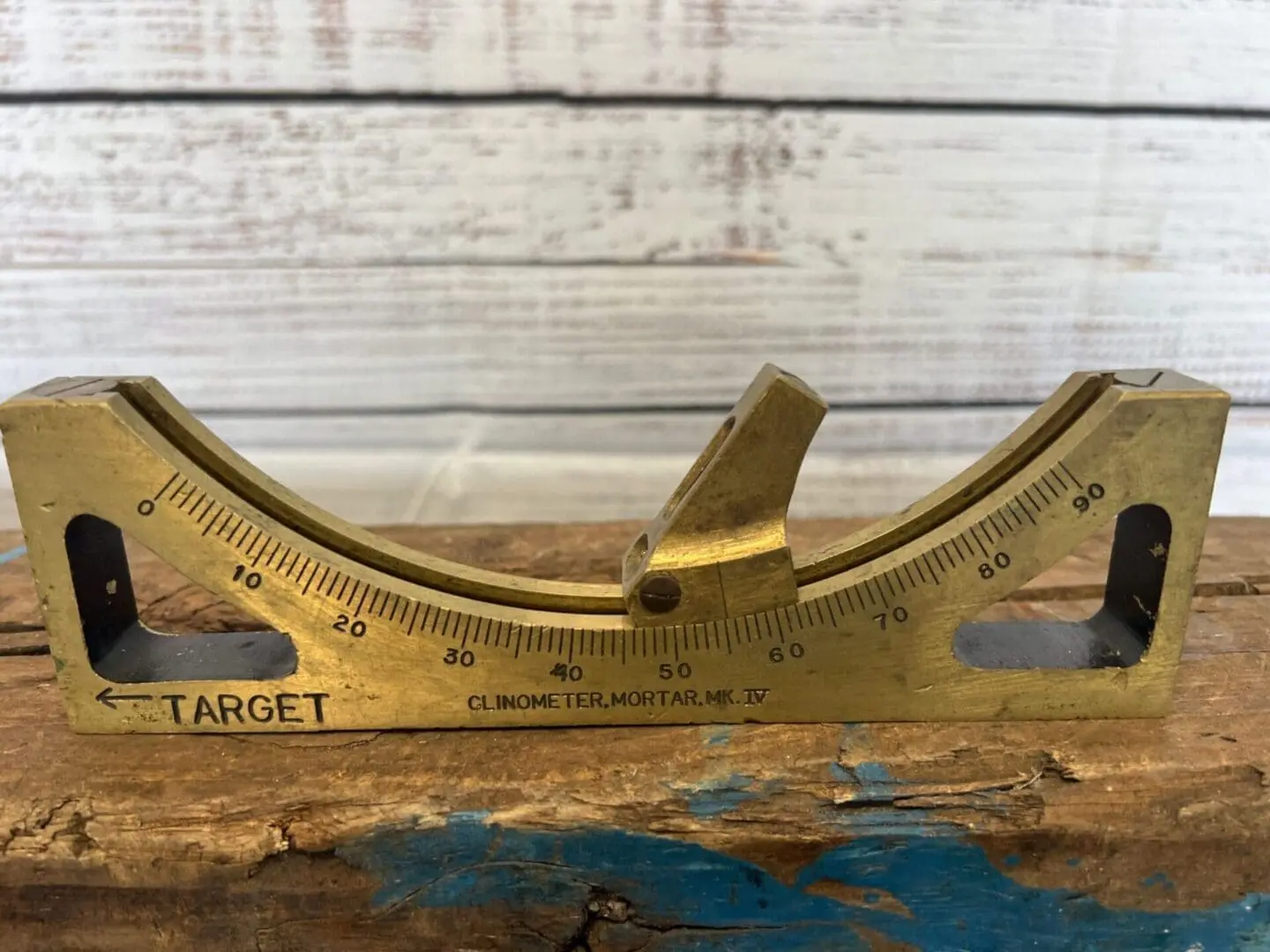 A close up of an angle meter on top of wood