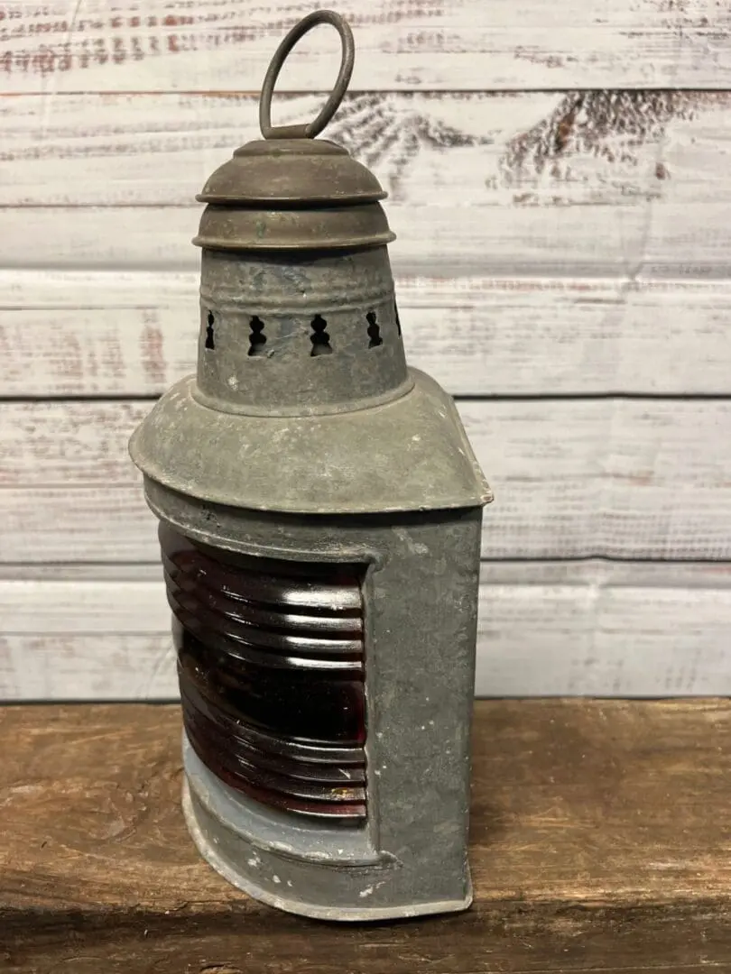 A metal lantern sitting on top of a wooden table.