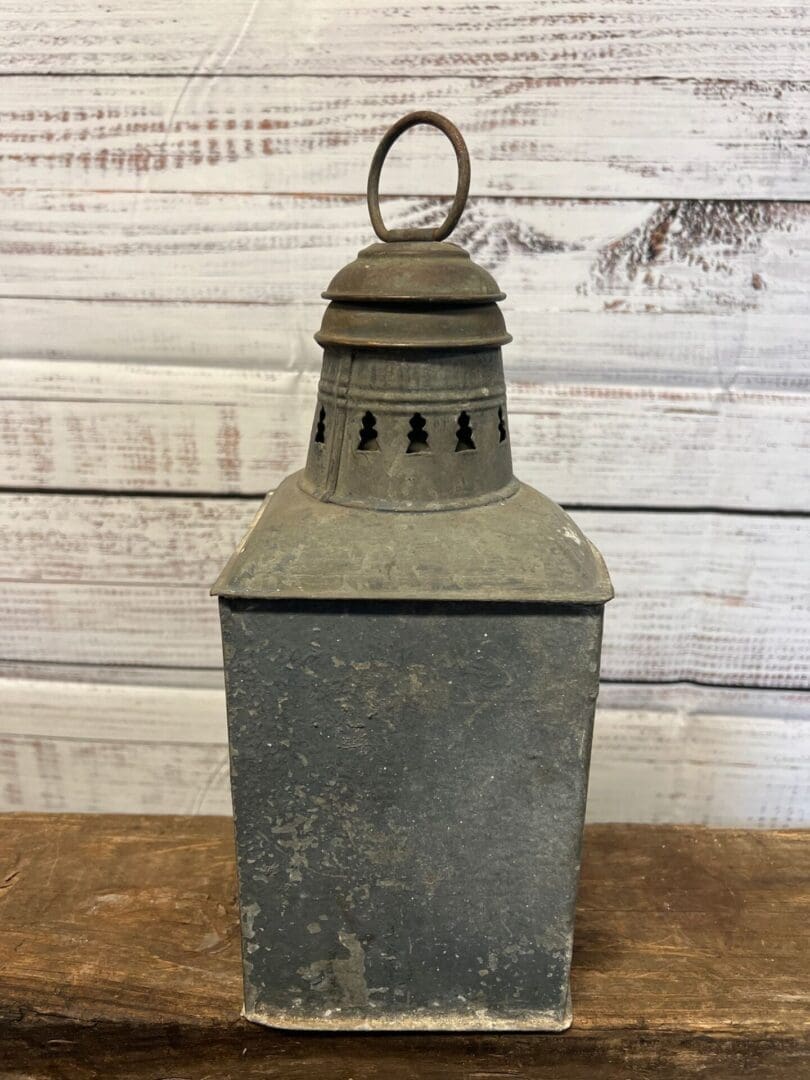 A metal lantern sitting on top of a table.