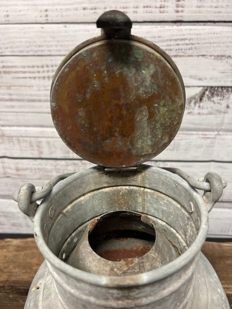 A metal pot with a lid on top of it.