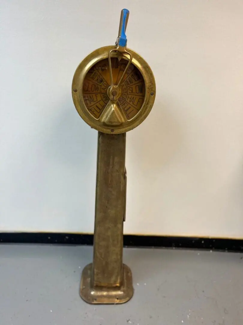 A gold clock on top of a metal pole.