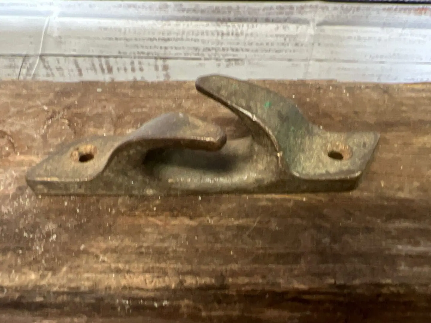 A rusty old wrench sitting on top of a wooden table.