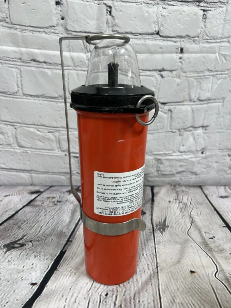 A red fire extinguisher sitting on top of a wooden table.