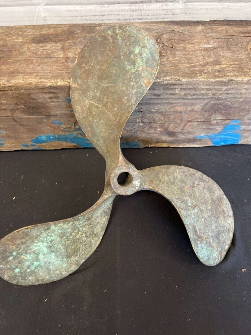 A rusted propeller sitting on top of a table.