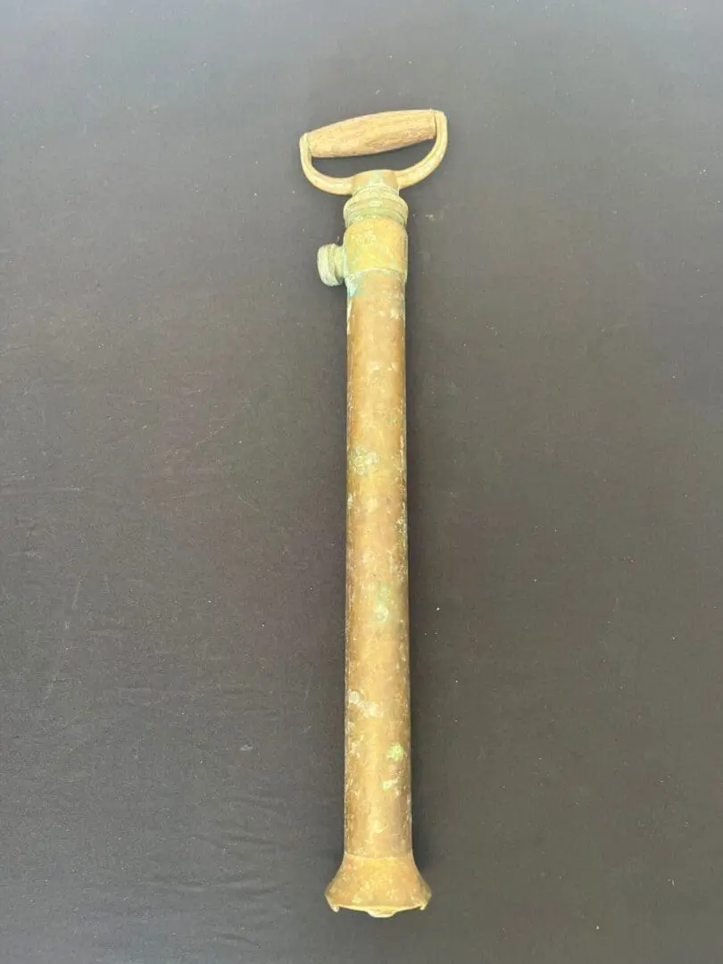 A gold colored handle with a bottle opener on it.