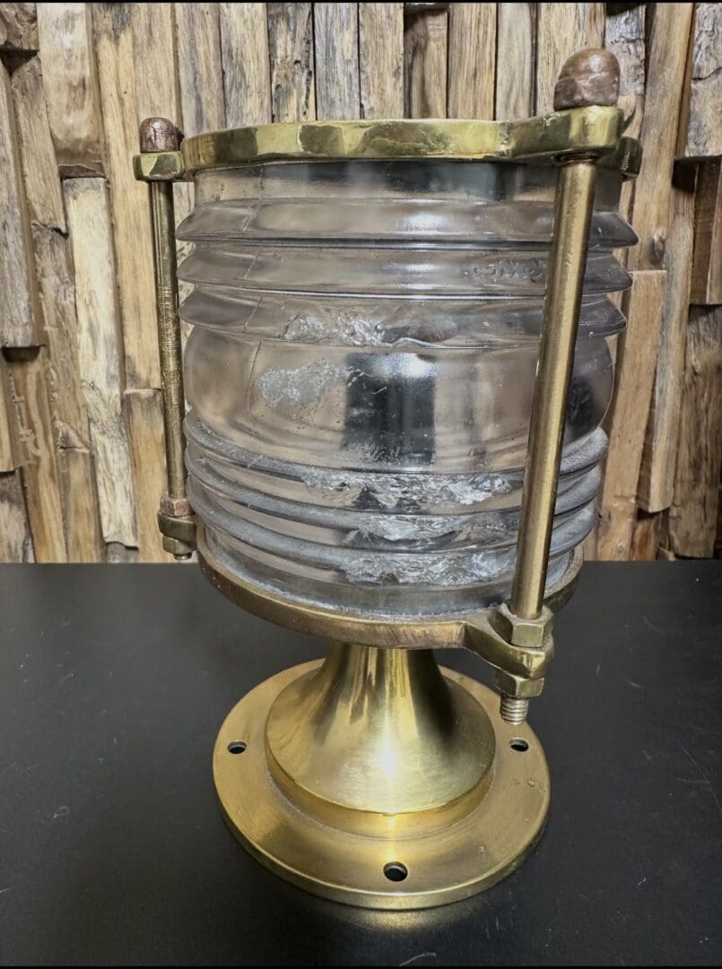 Antique brass and glass nautical lantern with a weathered look.