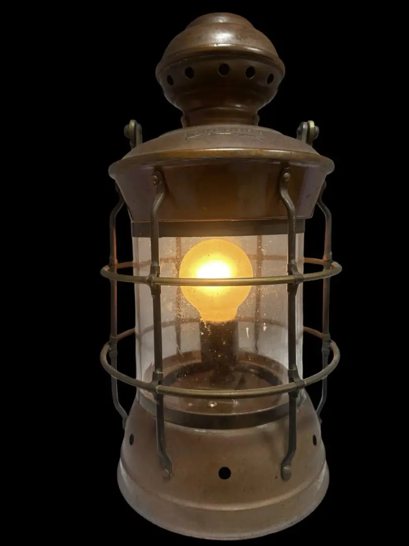 Antique copper lantern with lit bulb.