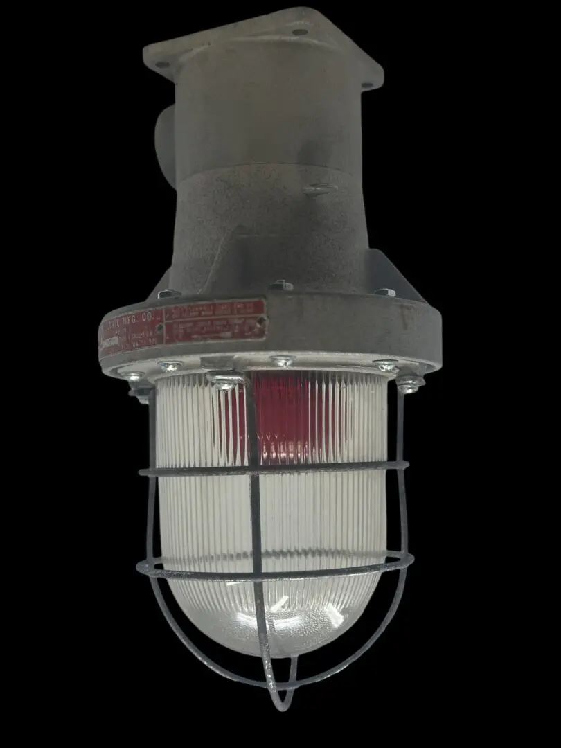Industrial caged light fixture with red lens.