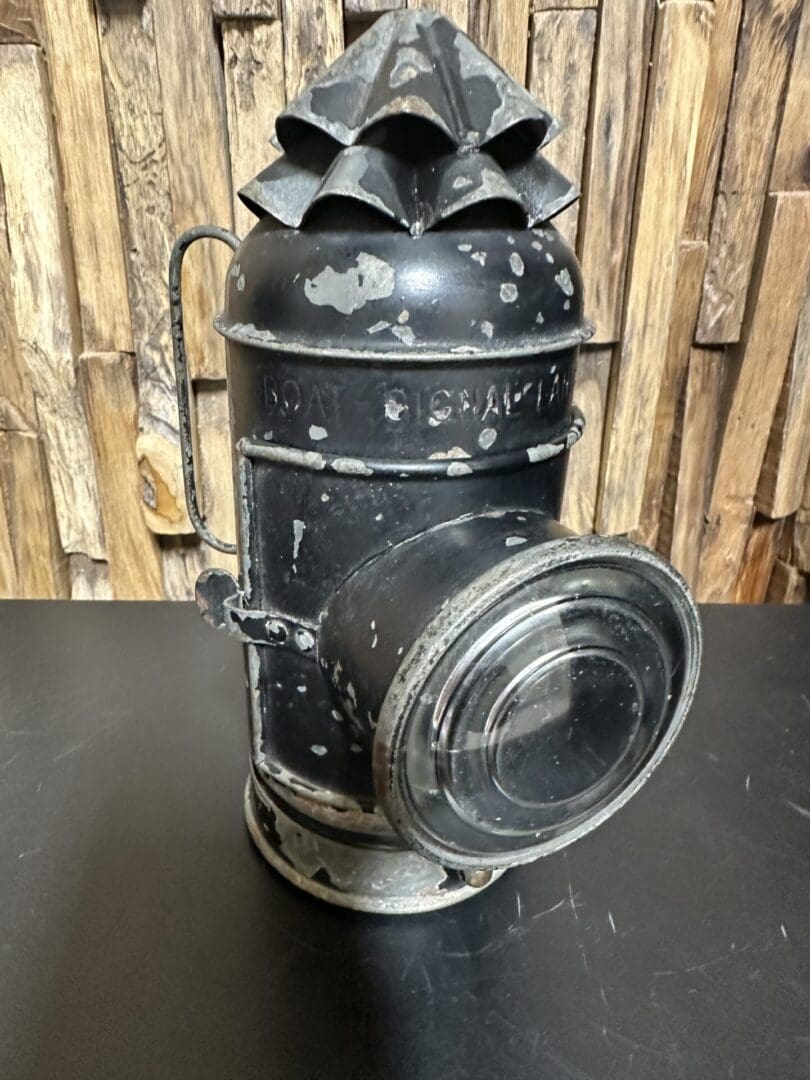 Vintage black metal lantern with a weathered finish and glass lens.