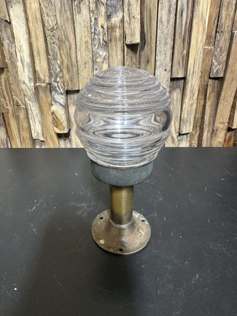 Vintage industrial light fixture with ribbed glass globe and metal base.